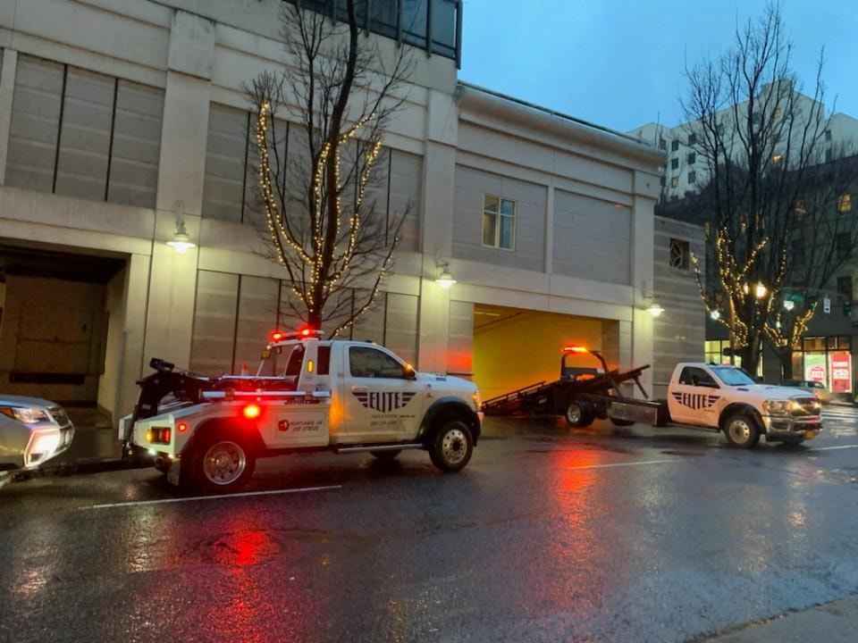 Two Elite Towing trucks in downtown Portland